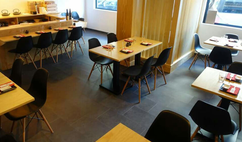 Mesas de madera con pie central y sillas nórdicas inspiración eames en color negro Mobiliario para hostelería nórdico en Genji Sushi Bar
